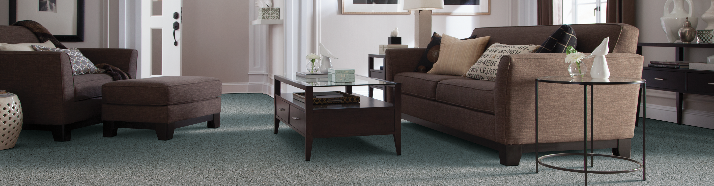 Greyish green carpet in living room with brown leather furnishings 