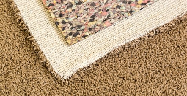 close up of tan textured carpet with backing and padding
